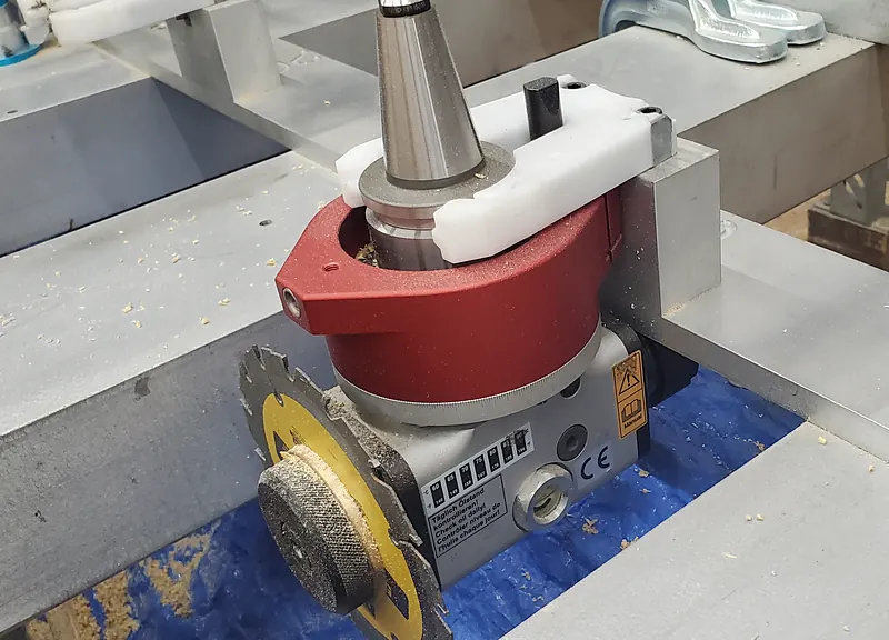 Angle head with a saw blade, mounted in a tool holder for side cutting on the CNC router