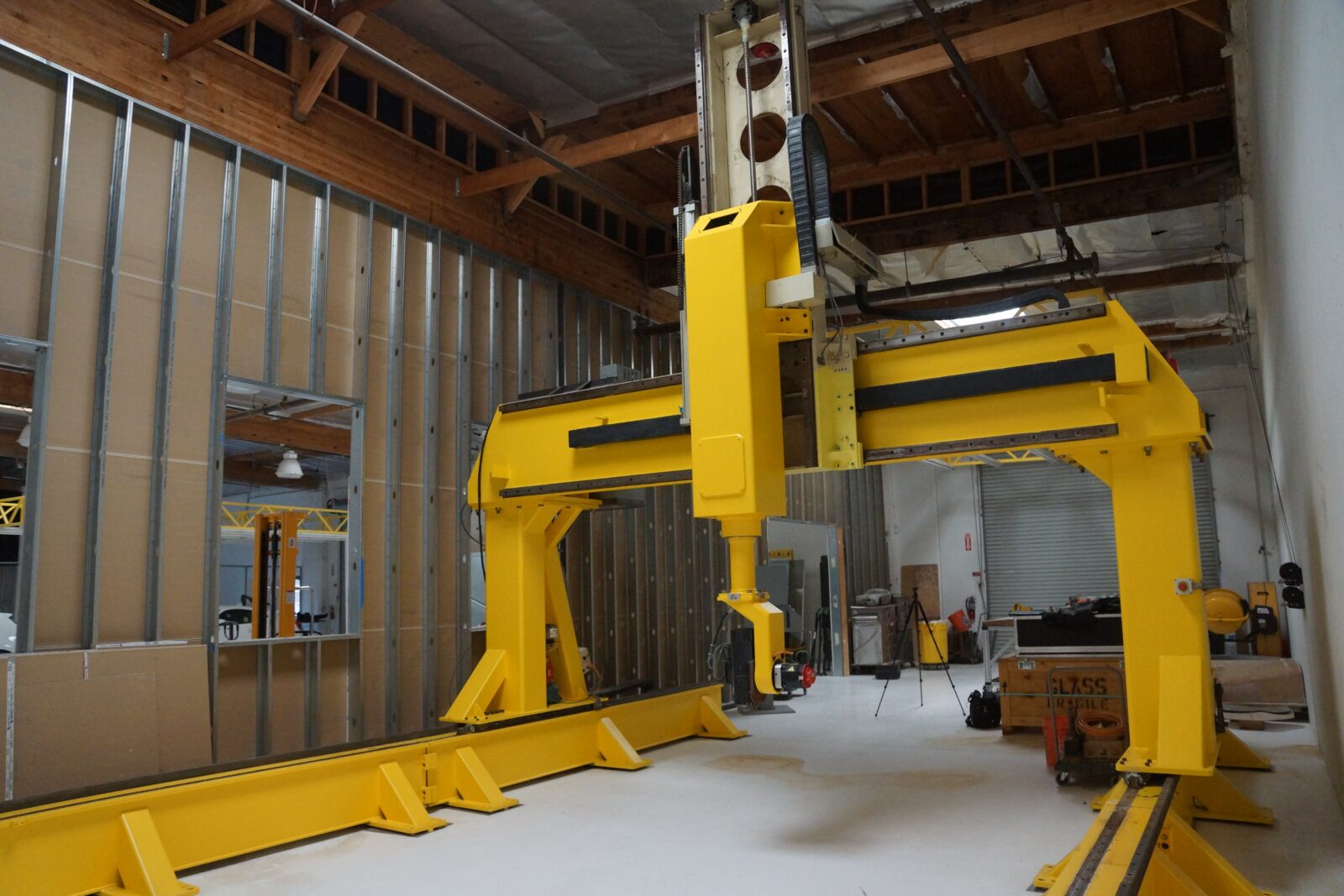 Large yellow full simultaneous 5-axis CNC router gantry on its rails